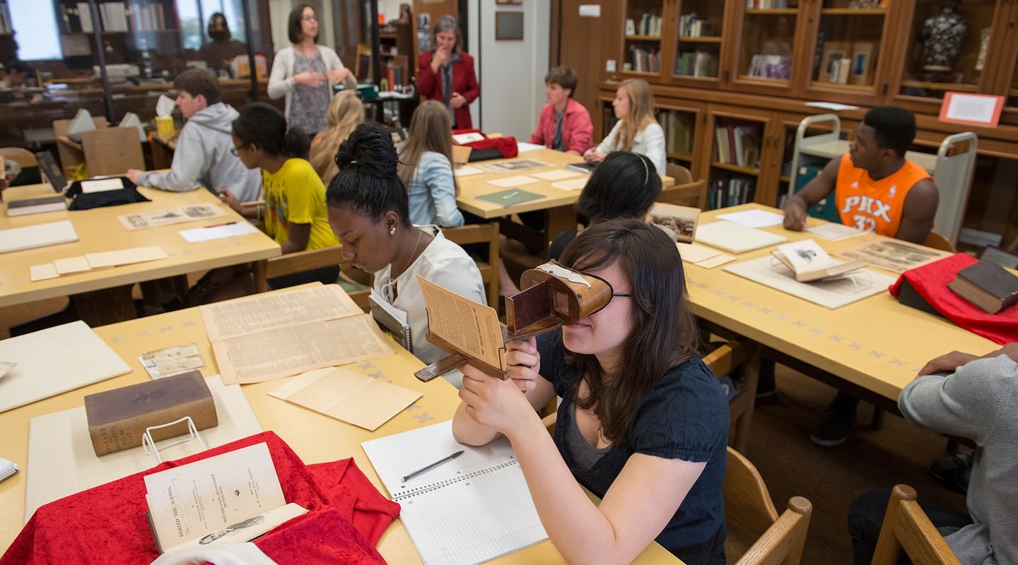Occidental College students working in Special Collections looking at old photos