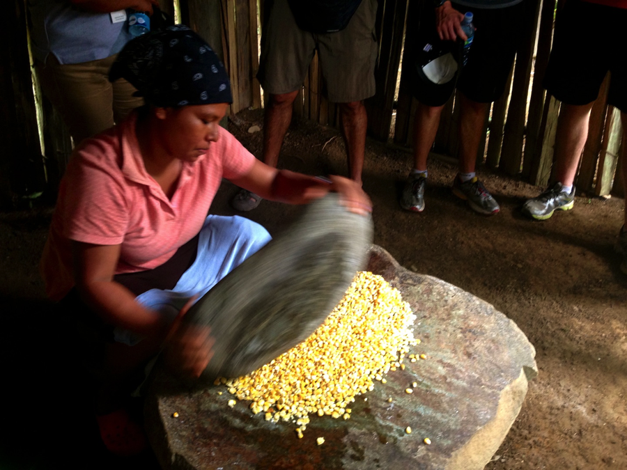 Bribri woman grinding maize the traditional way