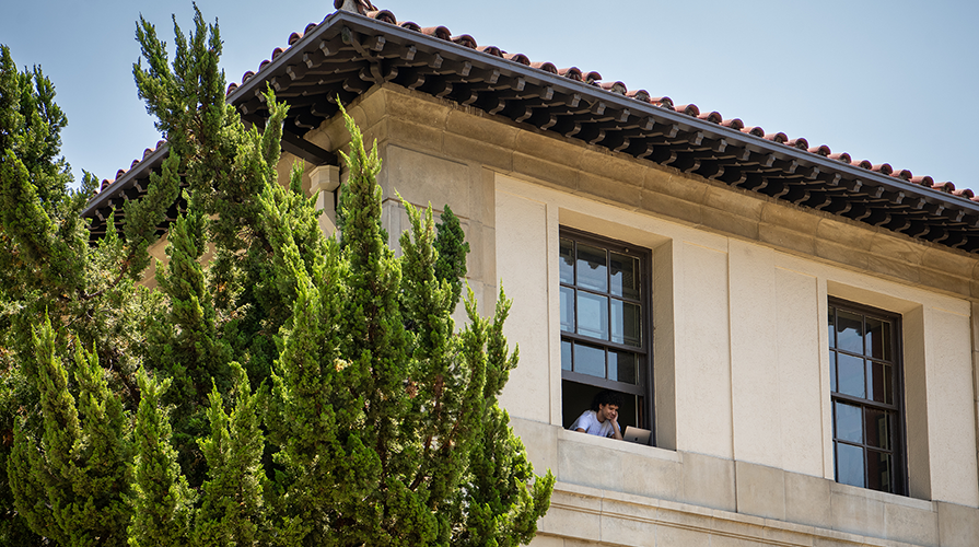 An Occidental student looks out the window from the upper levels of the Academic Commons