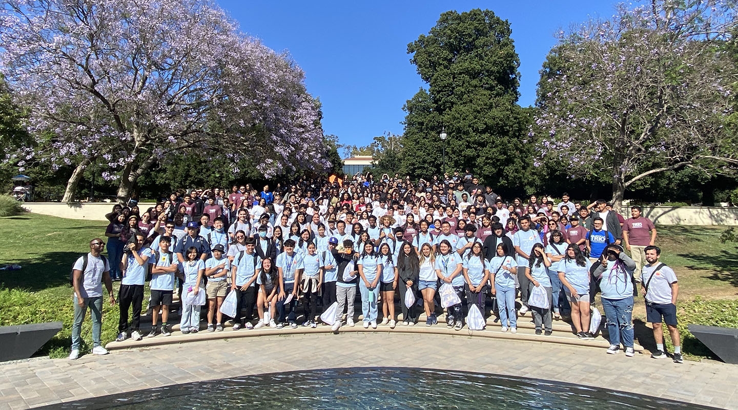 A large group of Upward Bound students pose on the steps by Gilman Fountain on campus