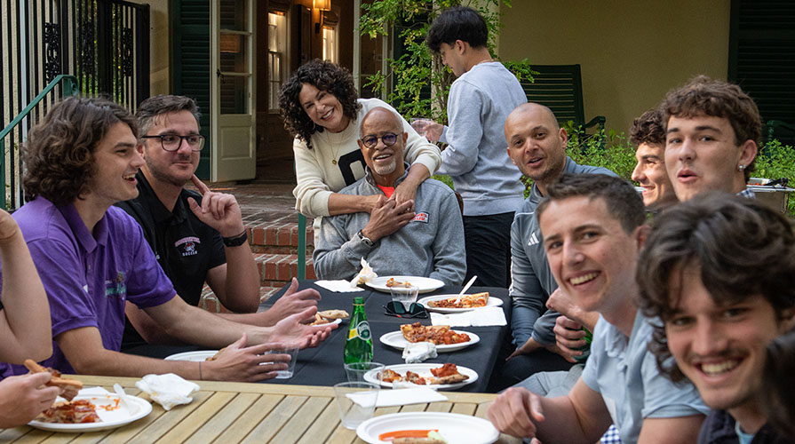 The Occidental College men's soccer team having a pizza party with President Elam and his wife Michele