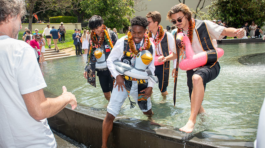 Occidental College students wading in Gilman Fountain on campus after Commencement