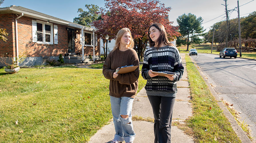 Two Occidental College students walking through a neighborhood in Allentown, PA, canvassing as part of Campaign Semester