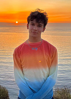 Occidental College student Blake Nicholas in front of an ocean sunset