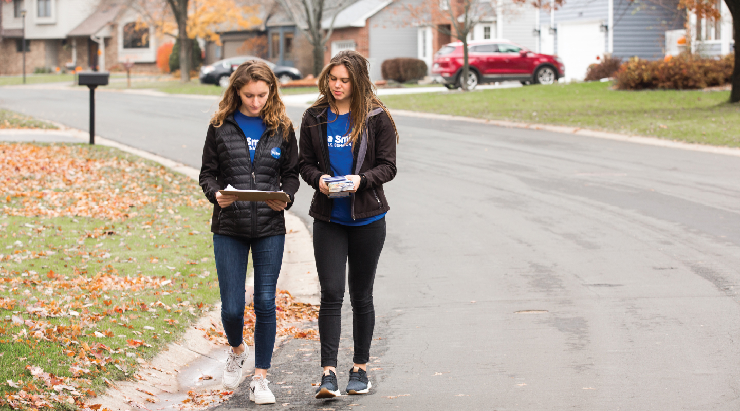 Two Occidental College Campaign Semester participants walking with clipboards in a neighborhood