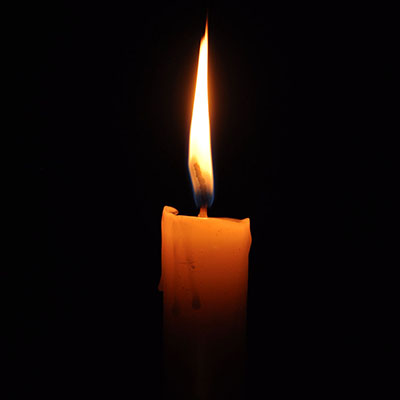 a candle burning against a black background