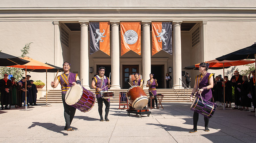 Taiko drummers make music in front of the Thorne Hall entrance on the Occidental College campus