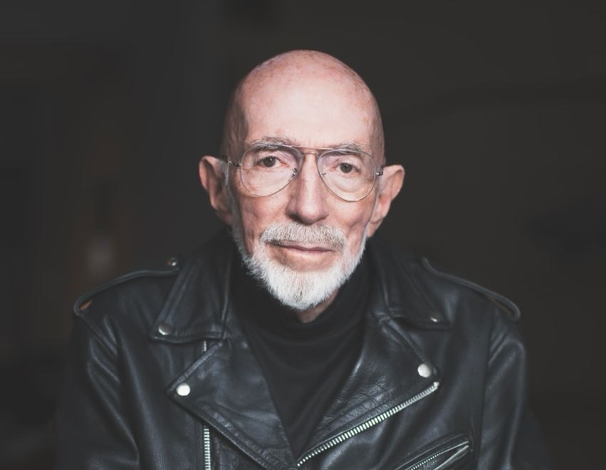 medium color portrait of Kip Thorne wearing a black leather motorcycle jacket and glasses, looking directly to camera