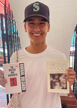 Occidental College student Max Malakoff holding up two books and smiling