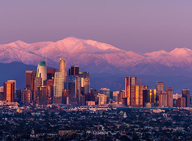 los angeles city skyline at sunset with mountains in background