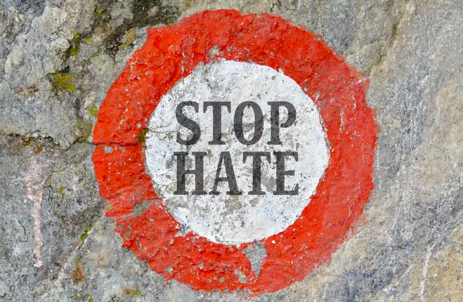 a red circle with white center and the words "stop hate"