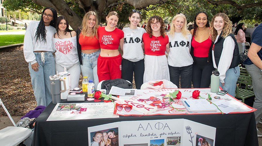 Members of the Occidental chapter of Alpha Lambda Phi Alpha pose together at a table on campus