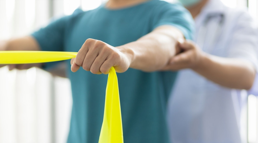 a physical therapy patient stretches using a resistance band