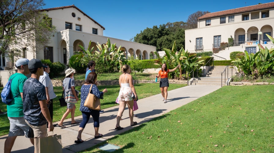 a student tour guide leads visitors around the Occidental College campus