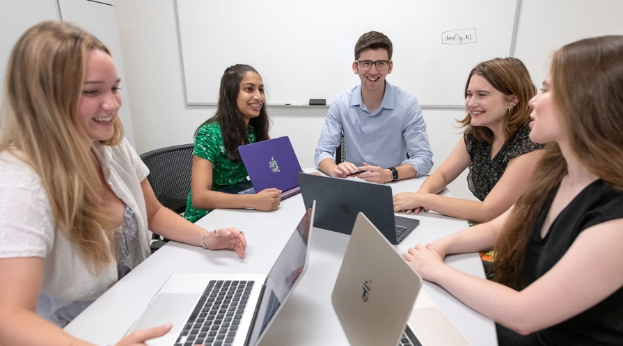 Occidental College professor Zachary Silver and four of his students at a table with their laptops