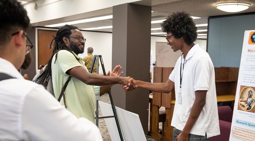 An Occidental College professor shakes hands with his student at the Undergraduate Research Conference