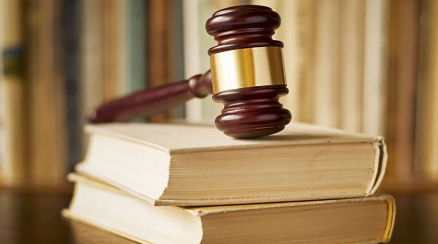 A gavel sitting on top of two thick law books