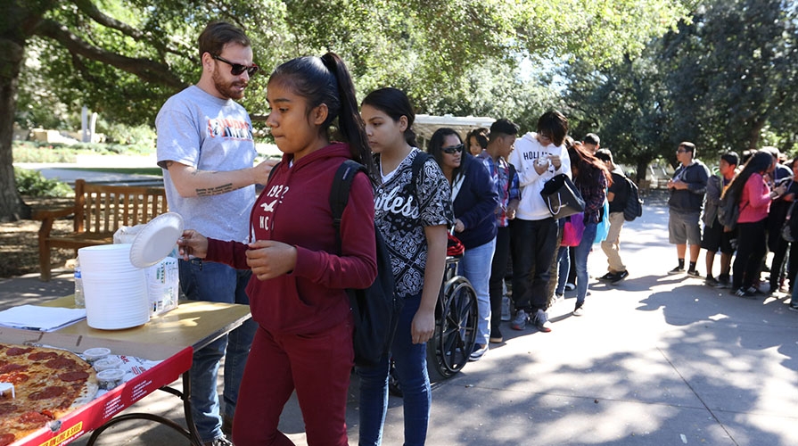 Elementary school students on the Occidental College campus lining up for pizza 