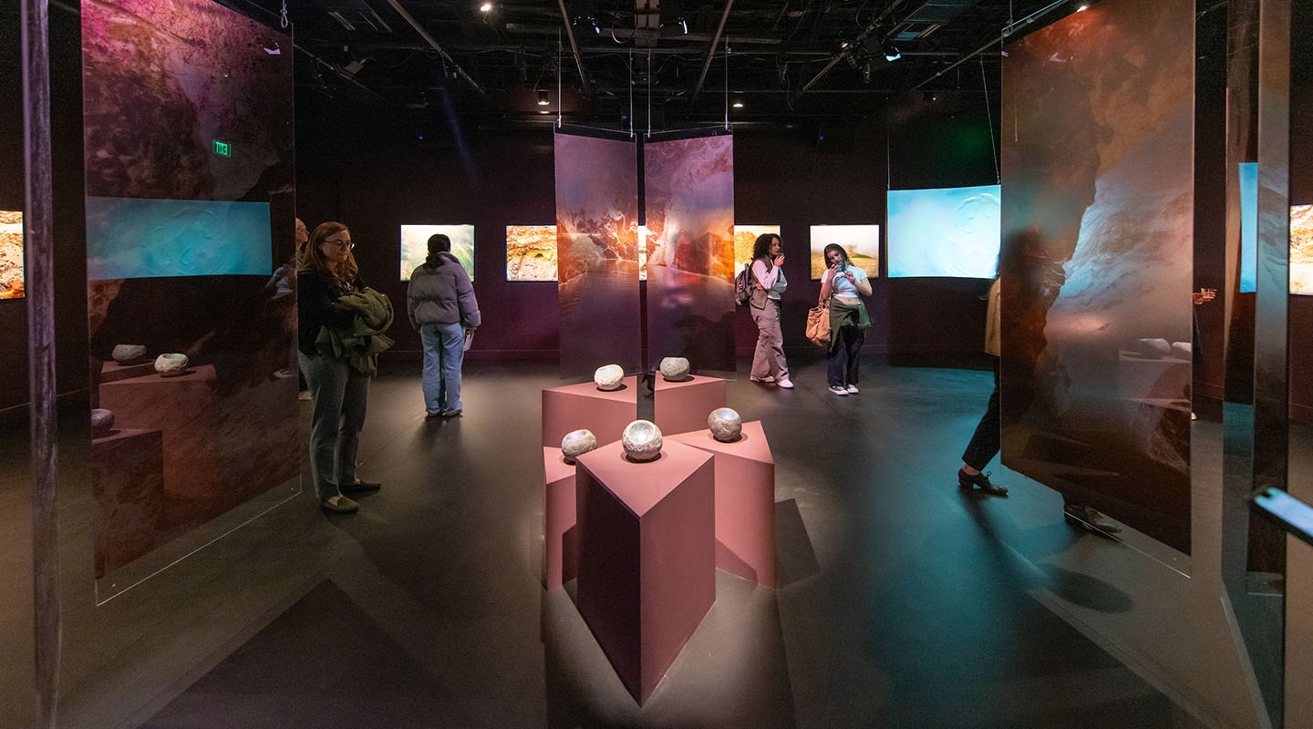 Inside an Oxy Arts exhibition gallery, with sculptures and hanging installments on either side.