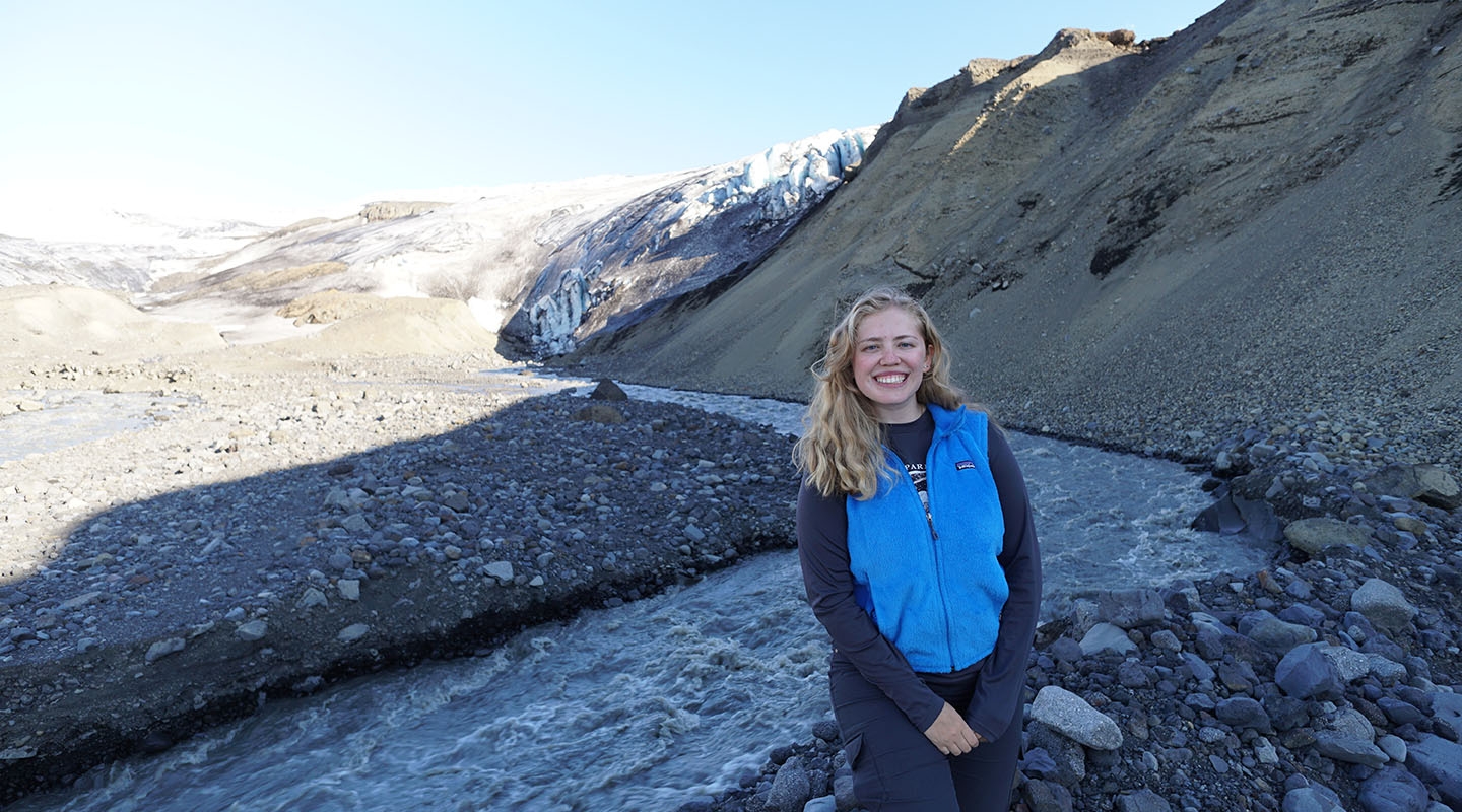 Occidental College alumna Lauren Berger '19 standing next to a glacier in Iceland