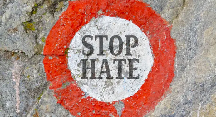 a red circle with white center and the words "stop hate"