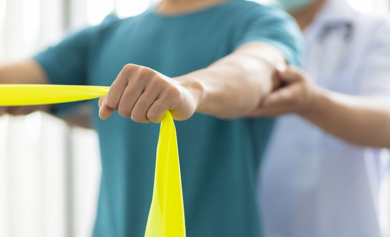 a physical therapy patient stretches using a resistance band