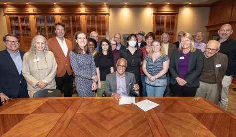 A group of Occidental College sustainability stakeholders gathered around President Elam signing a climate document
