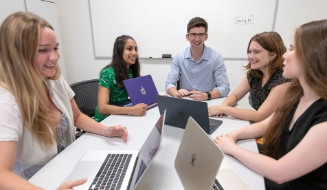 Occidental College professor Zachary Silver and four of his students at a table with their laptops