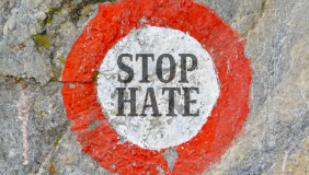 a red circle with white center and the words "stop hate"