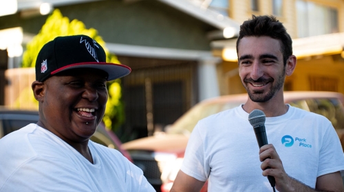 Oxy alumnus Ethan Glass '19, right, talking to a homeowner in South LA.